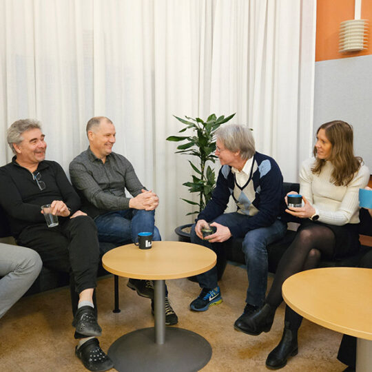 Group of people sitting in sofas drinking coffee