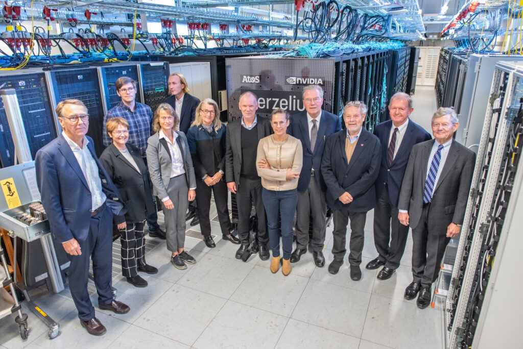 Group of people posing in front of supercomputer