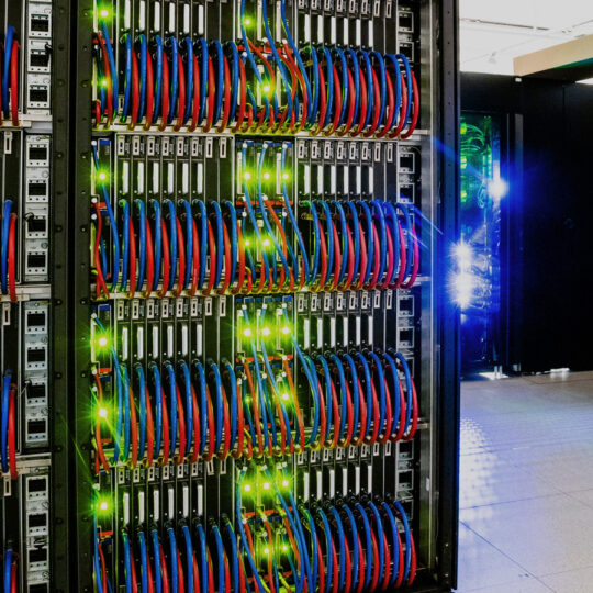 Photo of supercomputer with sharp green leds and red and blue cables