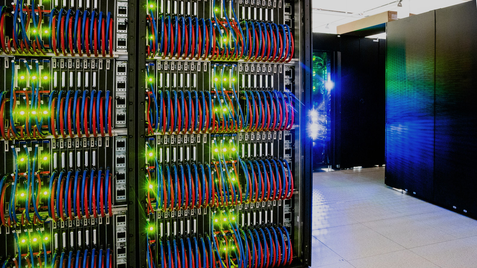 Photo of supercomputer with sharp green leds and red and blue cables